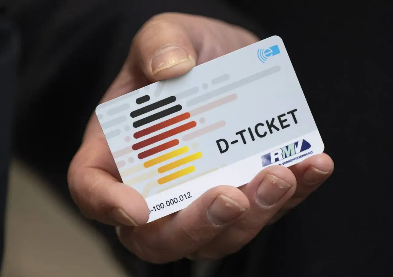 Ein personalisiertes Deutschlandticket in einer Hand. Das Ticket zeigt das D-Ticket Logo und den RMV-Verkehrsverbund.