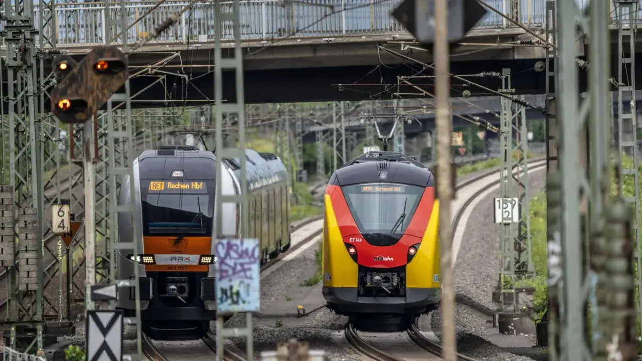 Zwei Z&uuml;ge, RE1 nach Aachen Hbf und RE34 nach Dortmund Hbf, fahren auf parallelen Gleisen in NRW.