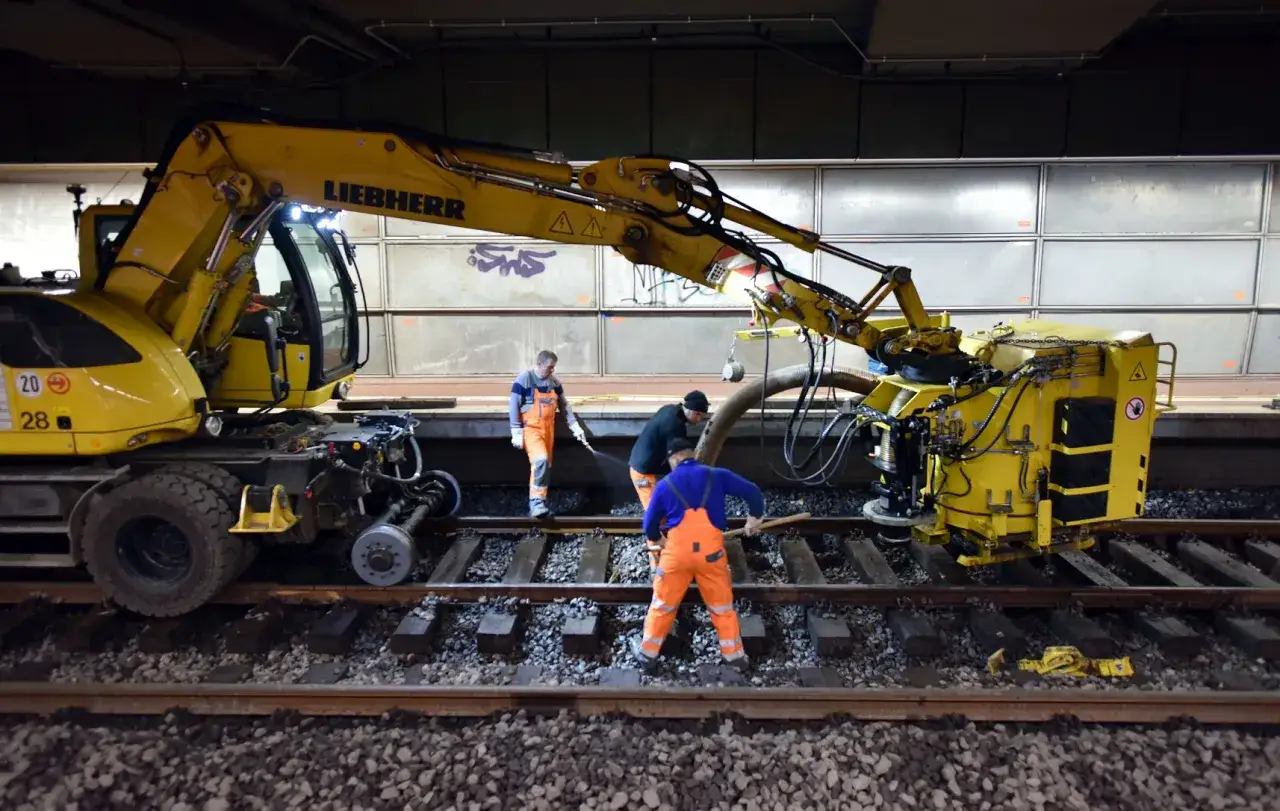 Arbeiter im Einsatz bei Bauarbeiten der Deutschen Bahn in NRW. Ein Bagger und Spezialger&auml;t auf den Gleisen.