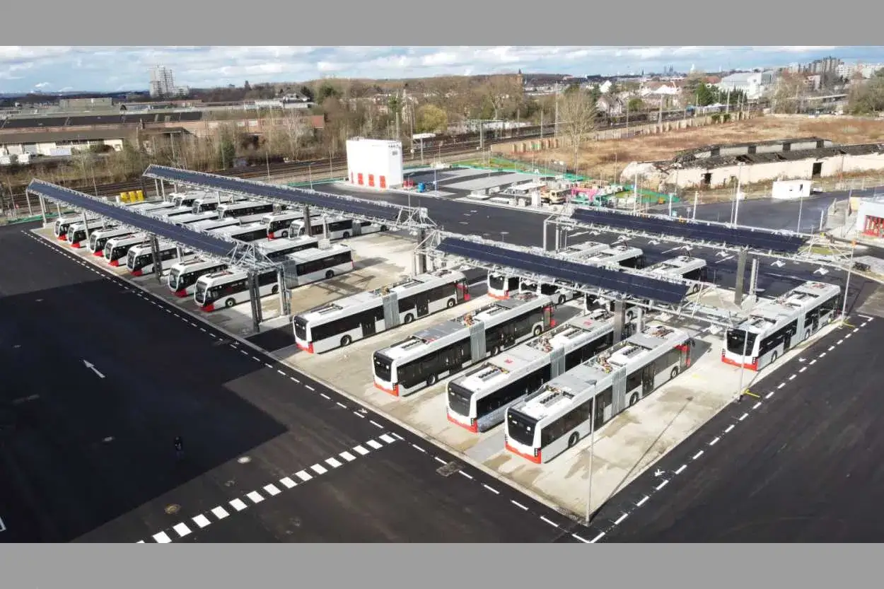 Reihe um Reihe stehen moderne, elektrische Busse unter Solard&auml;chern.
