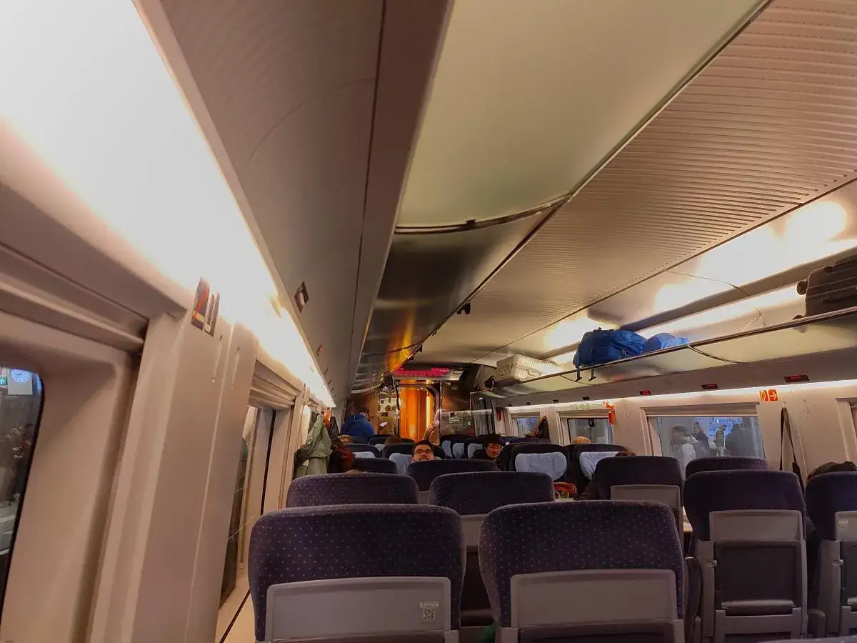 Innenraum eines Zugs mit blauen Sitzen. Mit dem Deutschlandticket nach den Niederlanden reisen.
