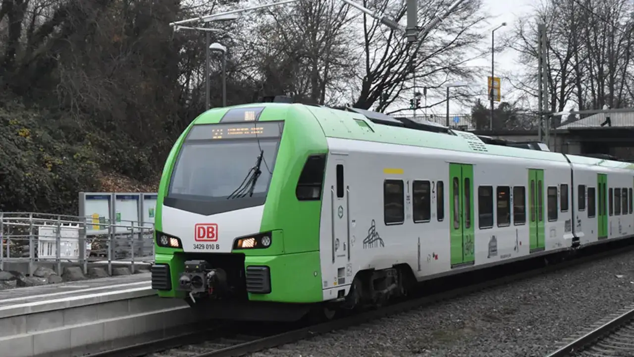 Gr&uuml;ner und wei&szlig;er Triebzug der Deutschen Bahn am Bahnsteig, bereit f&uuml;r die n&auml;chste Fahrt. Die Ausschreibung f&uuml;r den RRX-Betrieb hat zu solchen modernen Z&uuml;gen gef&uuml;hrt.