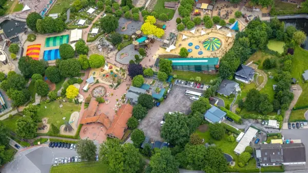 Luftaufnahme eines Freizeitparks mit bunten Spielplätzen, Trampolinen und viel Grün. Hier toben die nrw kids ausgelassen.